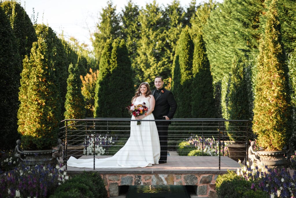 Bride and groom portrait on top of a bridge walkover in a garden at Larkfield in East Northport, NY