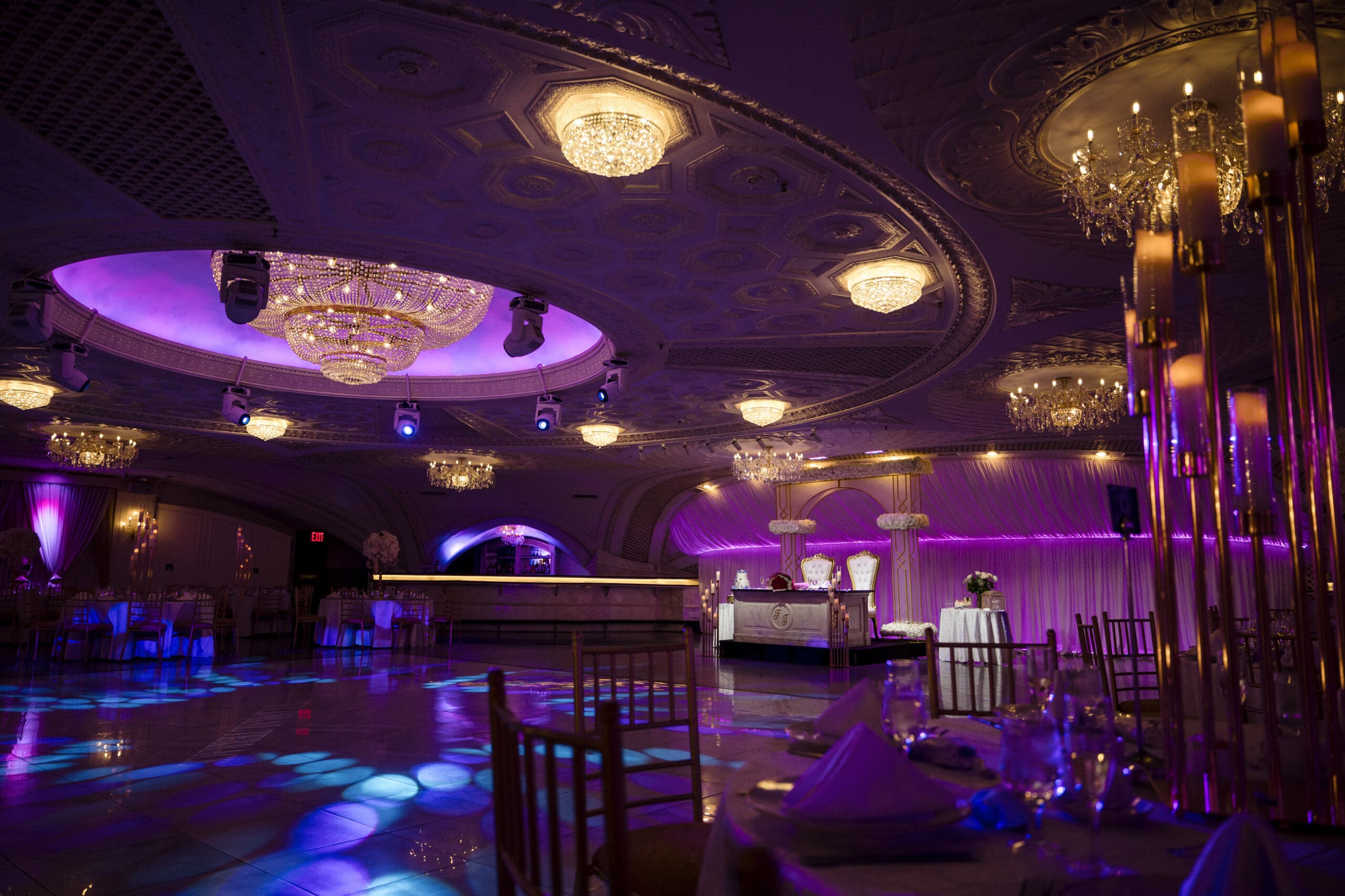 Wedding reception ballroom at Floral Terrace decorated and lit with purple uplighting